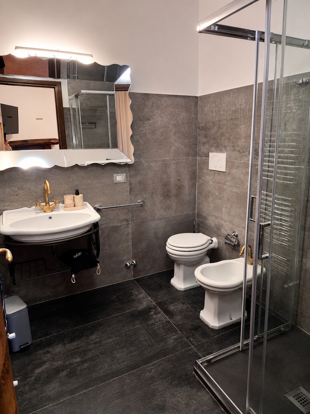 Ein modernes Badezimmer mit Duschkabine aus Glas, einem weißen Waschbecken und einer Toilette.