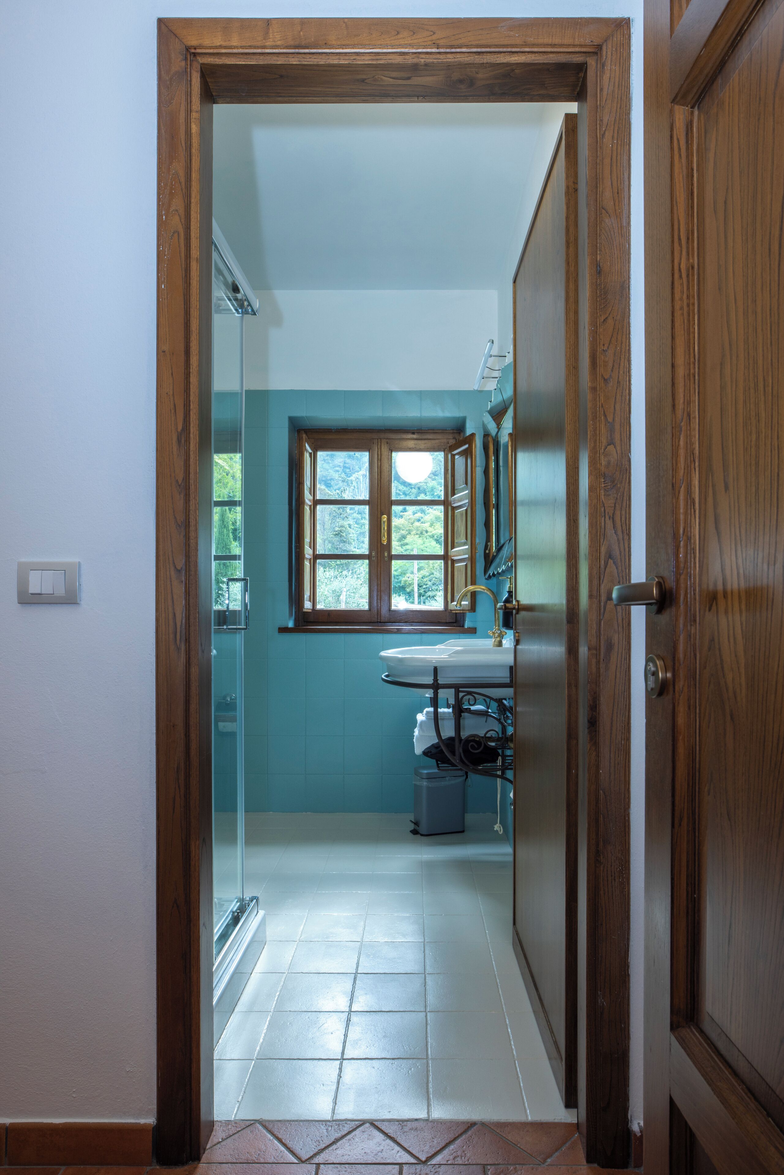 A bathroom with a window, a sink, and a mirror.