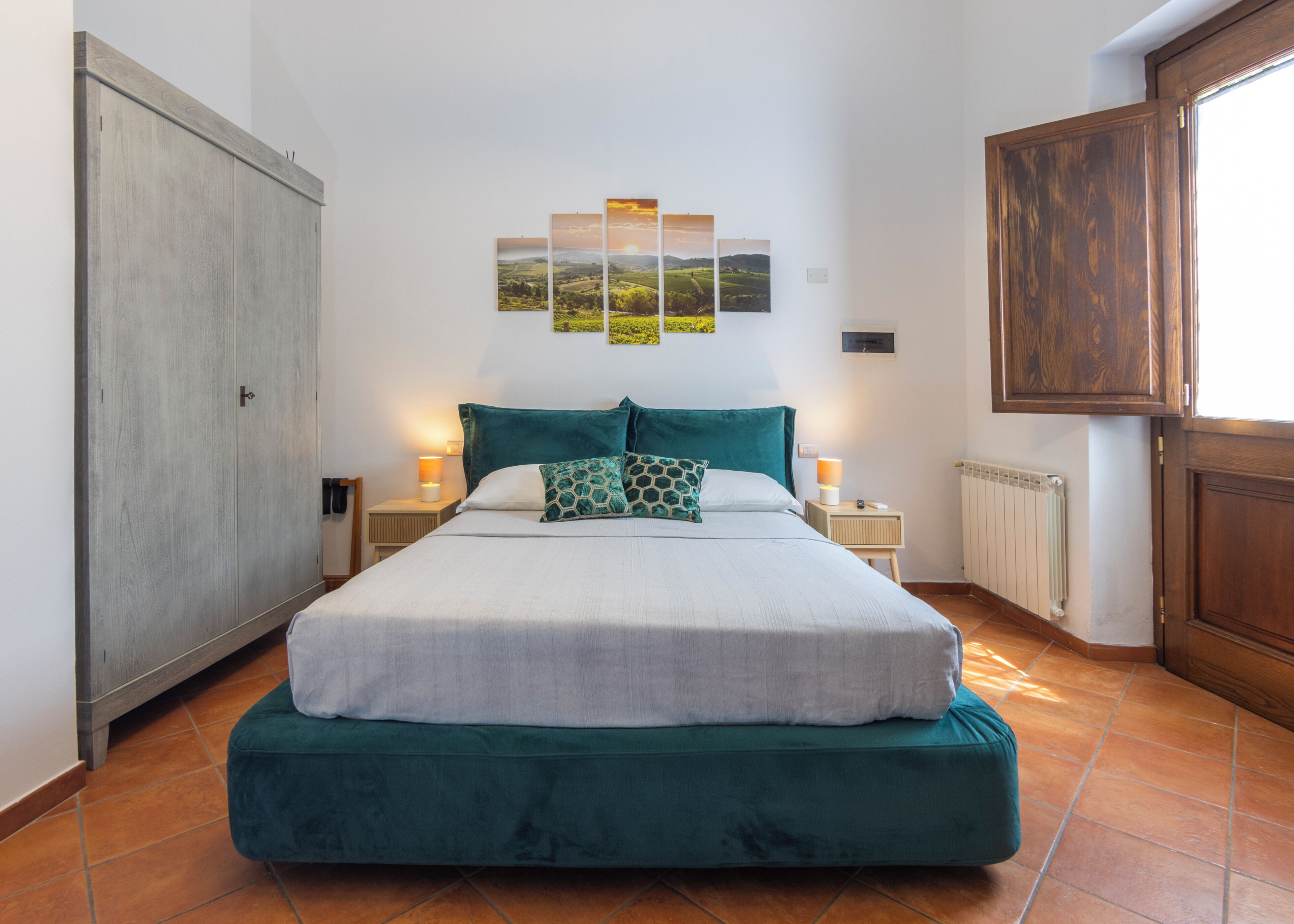 Una camera da letto con un letto, due comodini, un termosifone e un armadio.