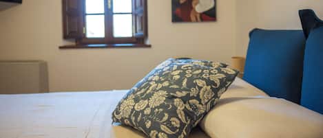 Un dormitorio con una cama, una ventana y un cuadro en la pared.
