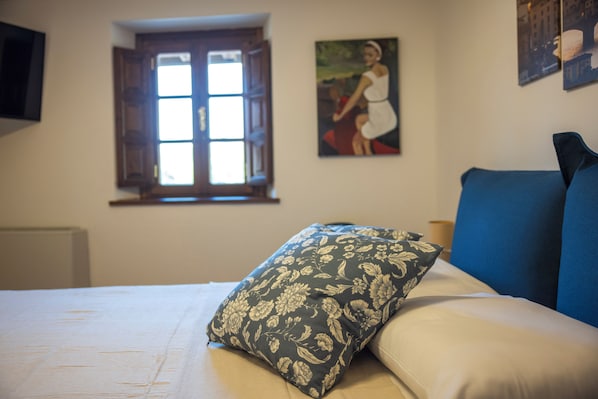 A bedroom with a bed, a window, and a painting on the wall. - Mulino La Sosta (Camaiore)