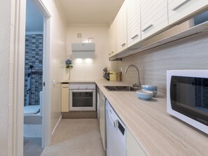 A compact kitchen with a microwave, sink, and oven. - Marinada Cambrils by Interhome (Cambrils)