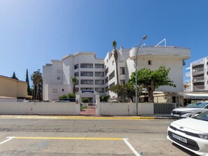 A multi-story building with a white facade, a gated entrance, and a clear blue sky. - Marinada Cambrils by Interhome (Cambrils)