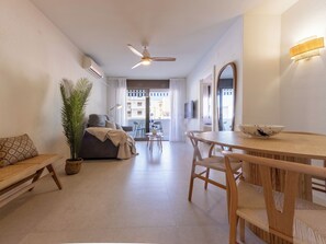 A modern living room with a sofa, dining table, chairs, a ceiling fan, and a potted plant. - Marinada Cambrils by Interhome (Cambrils)