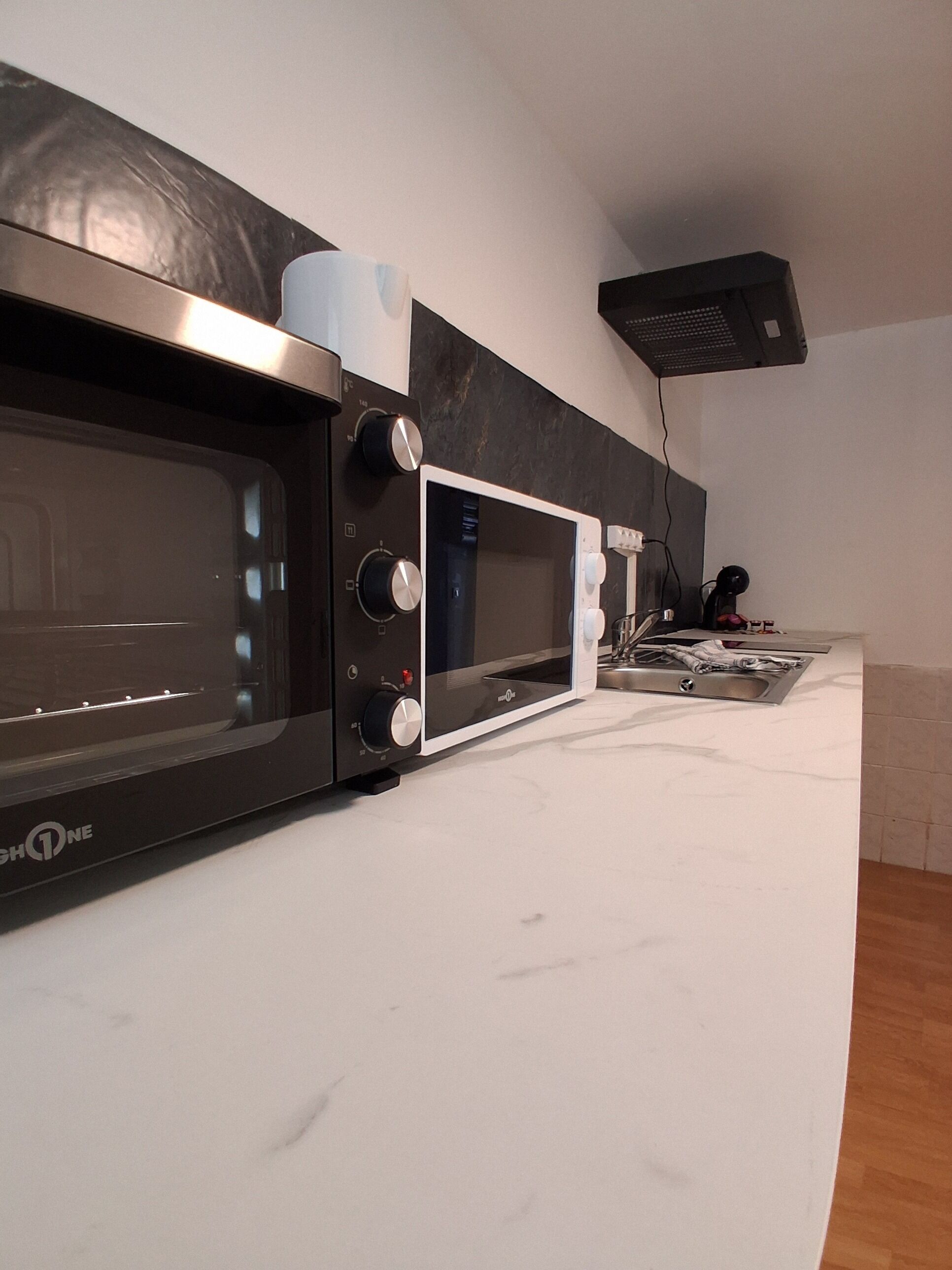 A kitchen with a microwave, a toaster, and a kettle.