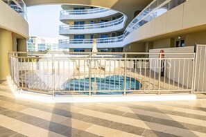 A modern indoor swimming pool with a glass ceiling, surrounded by a metal railing and a tiled floor. - Bloomfields 1BR Ajwan- Saadiyat  (Abu Dhabi)
