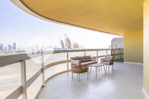 A balcony with a city view, a sofa, and a small table. - Bloomfields 1BR Ajwan- Saadiyat  (Abu Dhabi)