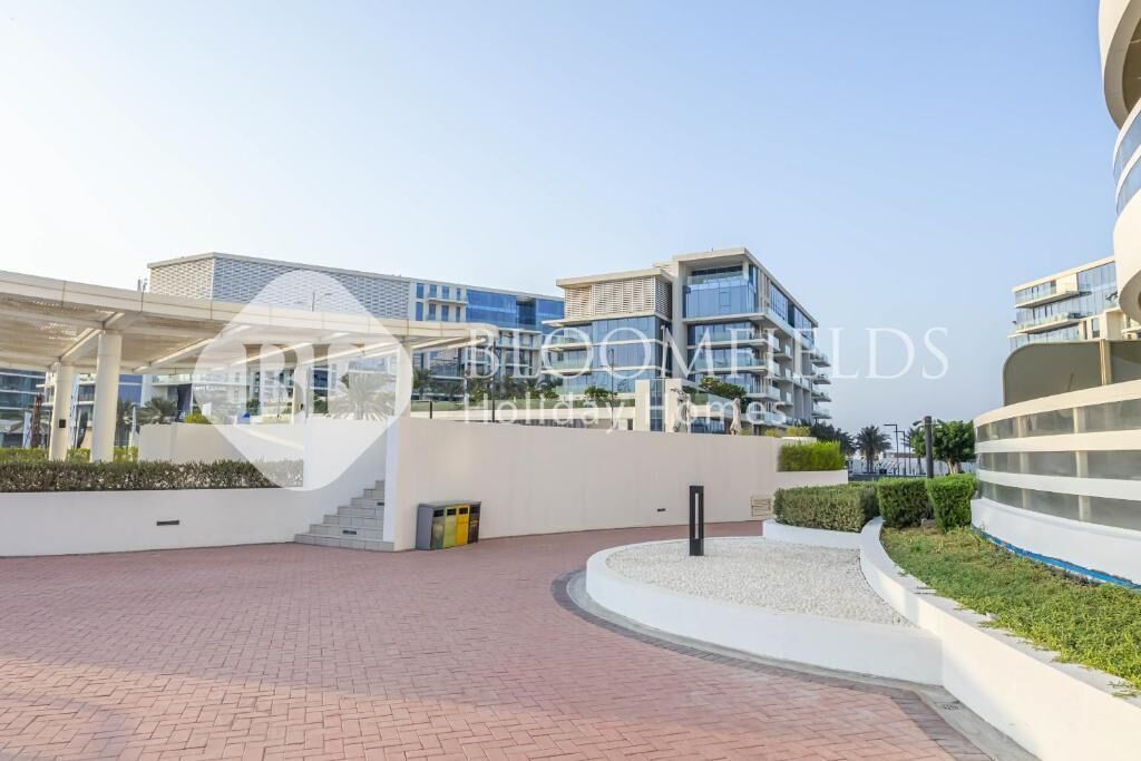 A modern building complex with a central courtyard, featuring a mix of residential and commercial structures.