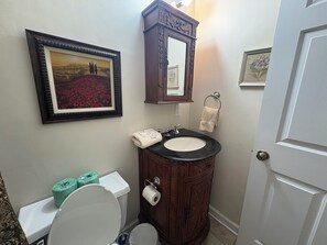 Ein Badezimmer mit Toilette, Waschbecken und Spiegel.