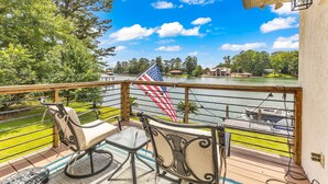 Une terrasse avec vue sur un lac, un drapeau américain et un bateau.