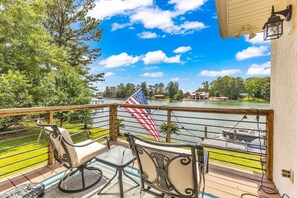 Une terrasse avec vue sur un lac, un drapeau américain et un bateau.