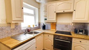 A kitchen with a sink, stove, and toaster.