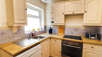 A kitchen with a sink, stove, and toaster.