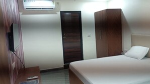 A bedroom with a bed, a wardrobe, and an air conditioning unit. - STAYAURA BY ROH (Guwahati)