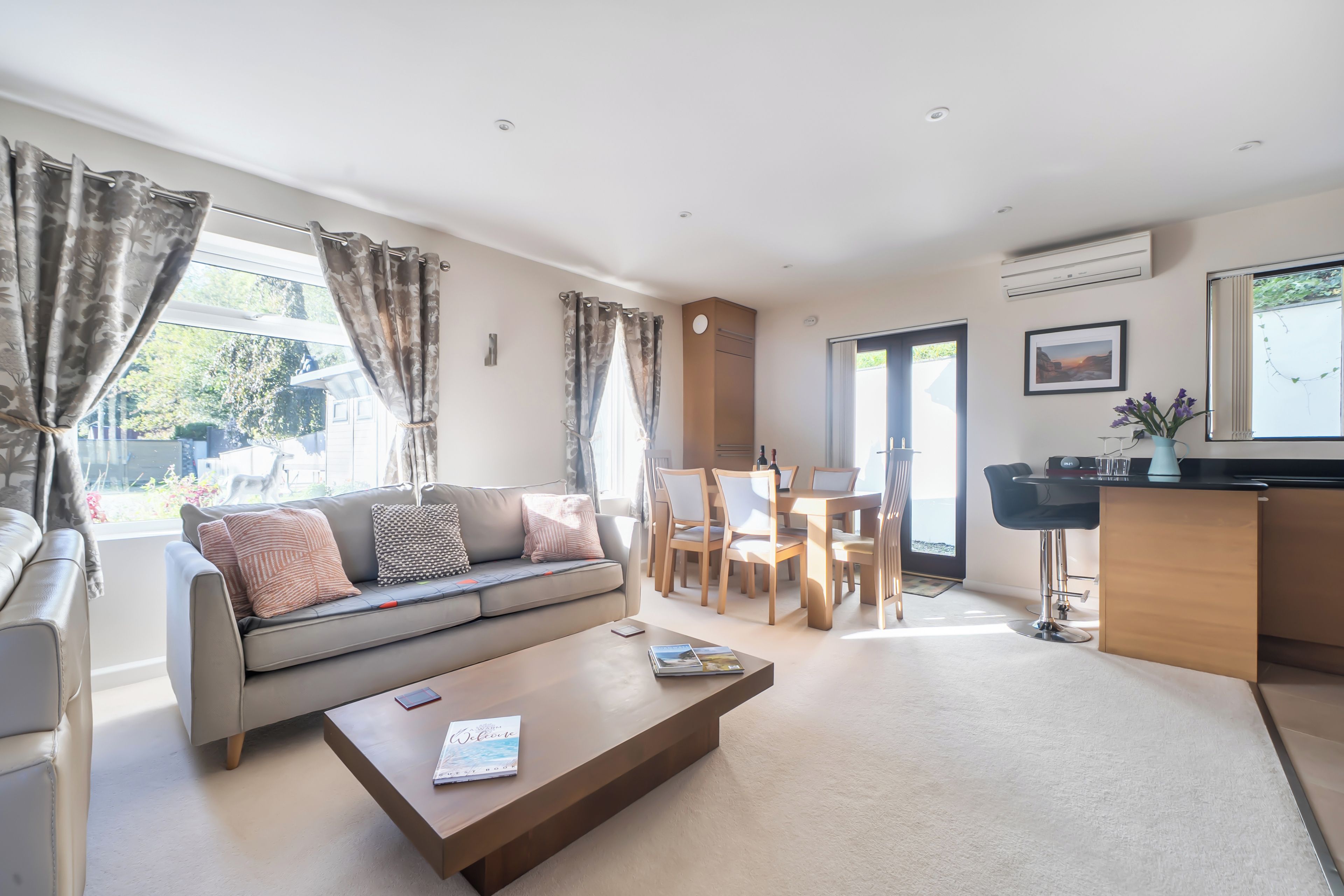 A modern living room with a sofa, coffee table, and dining area.