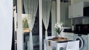 Une cuisine moderne équipée d’un four à micro-ondes, d’un lave-linge et d’un coin repas avec une table et des chaises.