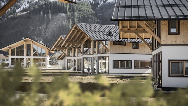 A row of wooden cabins with large windows and a metal roof, set against a mountainous backdrop. - Chalet With Mountain Views, Dein Bichlbach (Bichlbach)