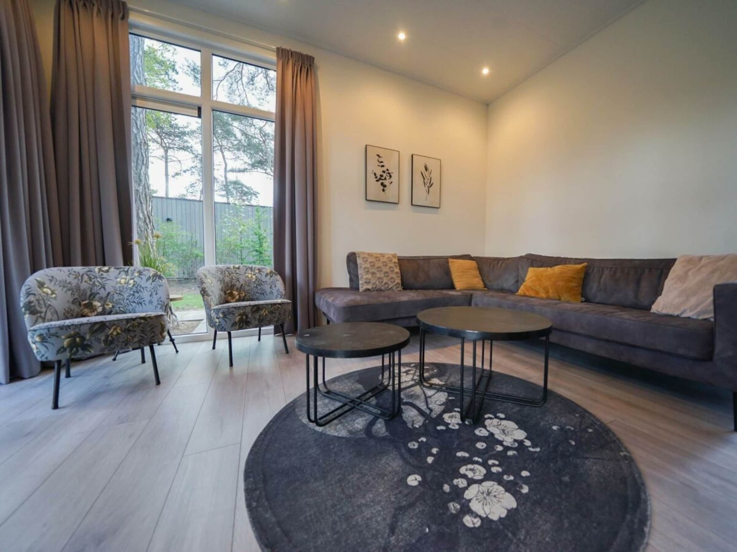 A living room with a sofa, two armchairs, a coffee table, and a rug.