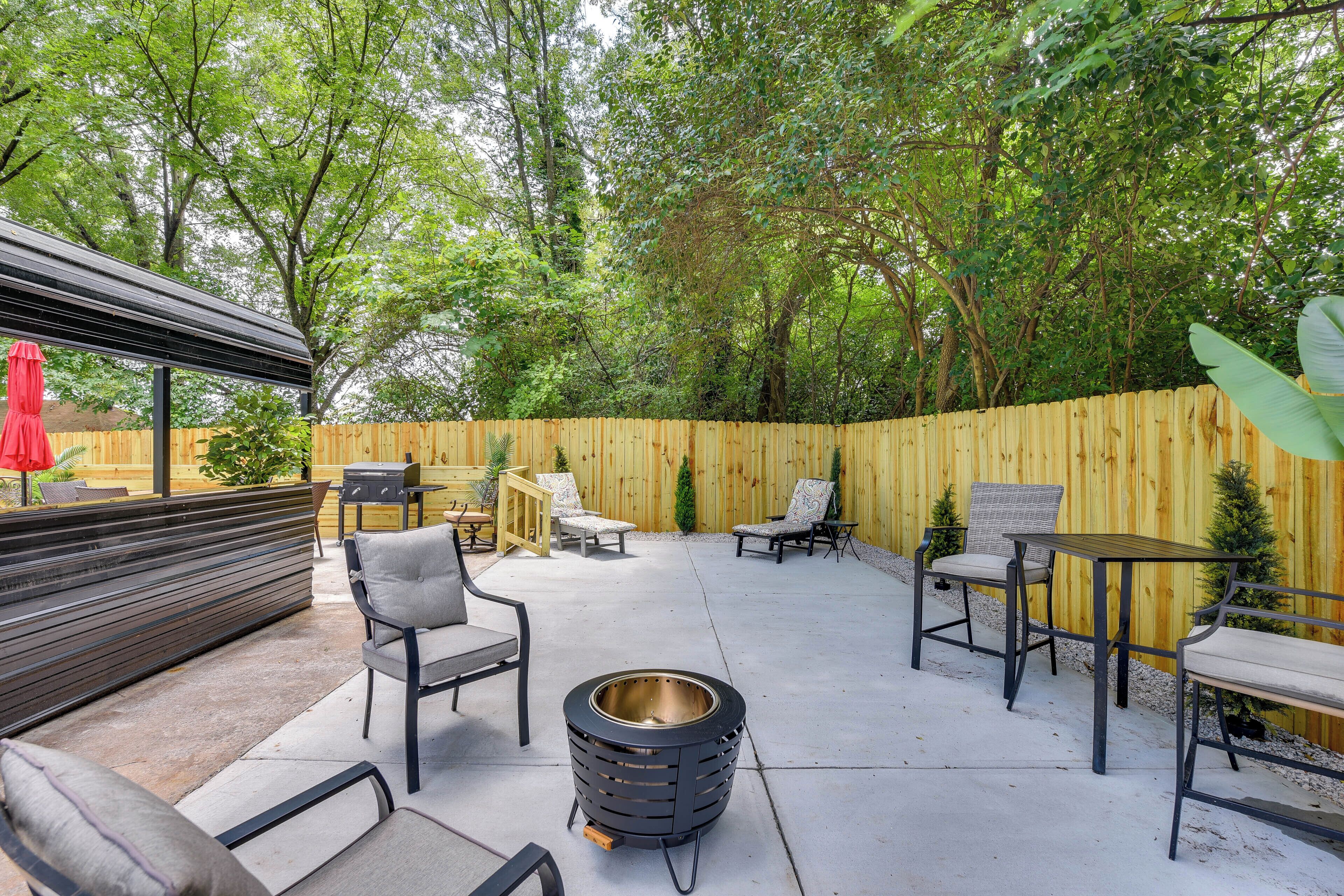 A patio with outdoor furniture, a fire pit, and a wooden fence.
