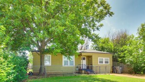 A single-story house with a fenced yard, a tree, and a trash bin. - 3 Mi to Fort Sill! Family Retreat w/ Fenced Yard (Lawton)