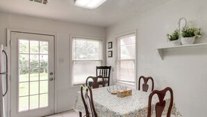 A dining area with a table, chairs, a refrigerator, and windows. - 3 Mi to Fort Sill! Family Retreat w/ Fenced Yard (Lawton)