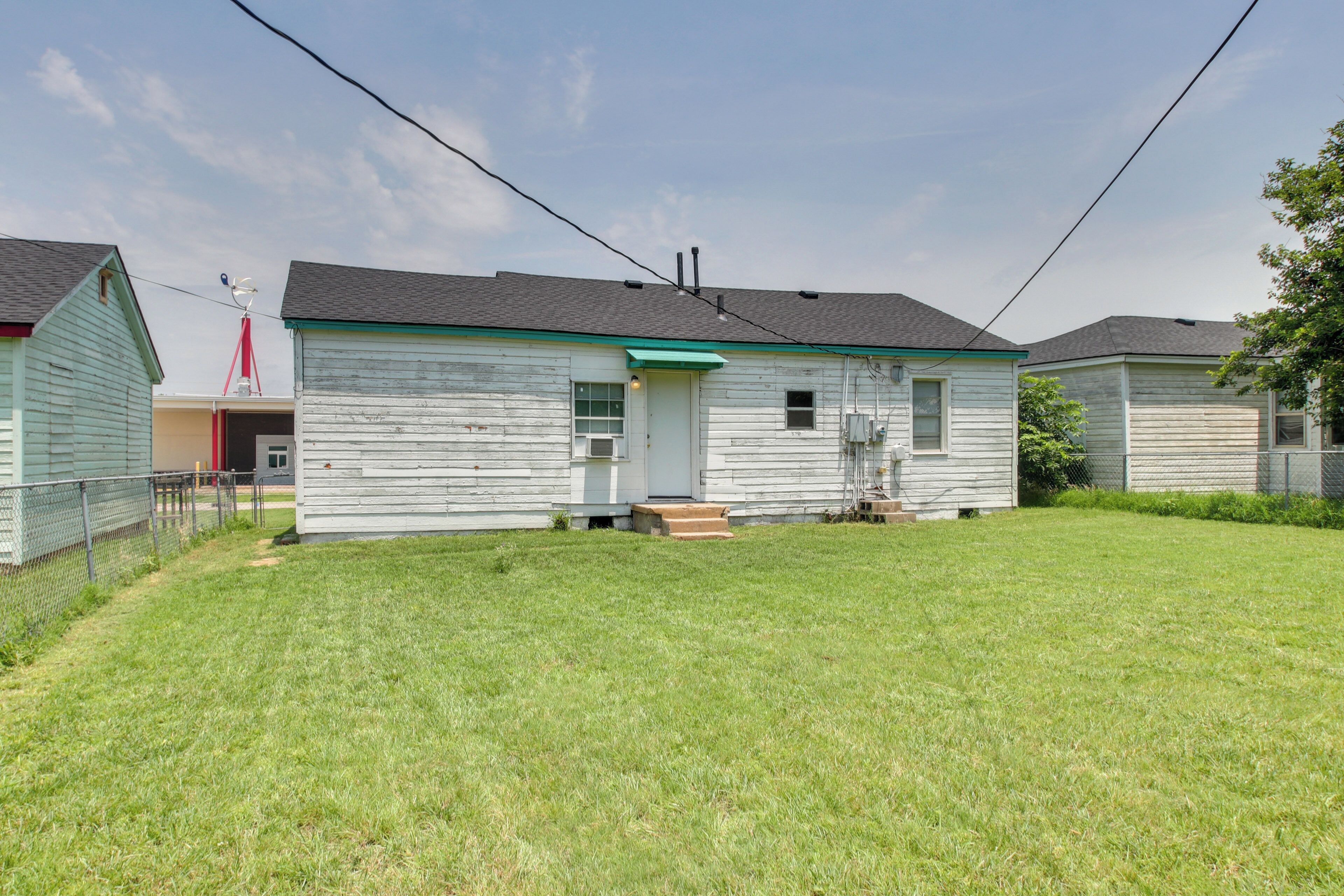 A single-story house with a front porch, a small front yard, and a visible satellite dish.