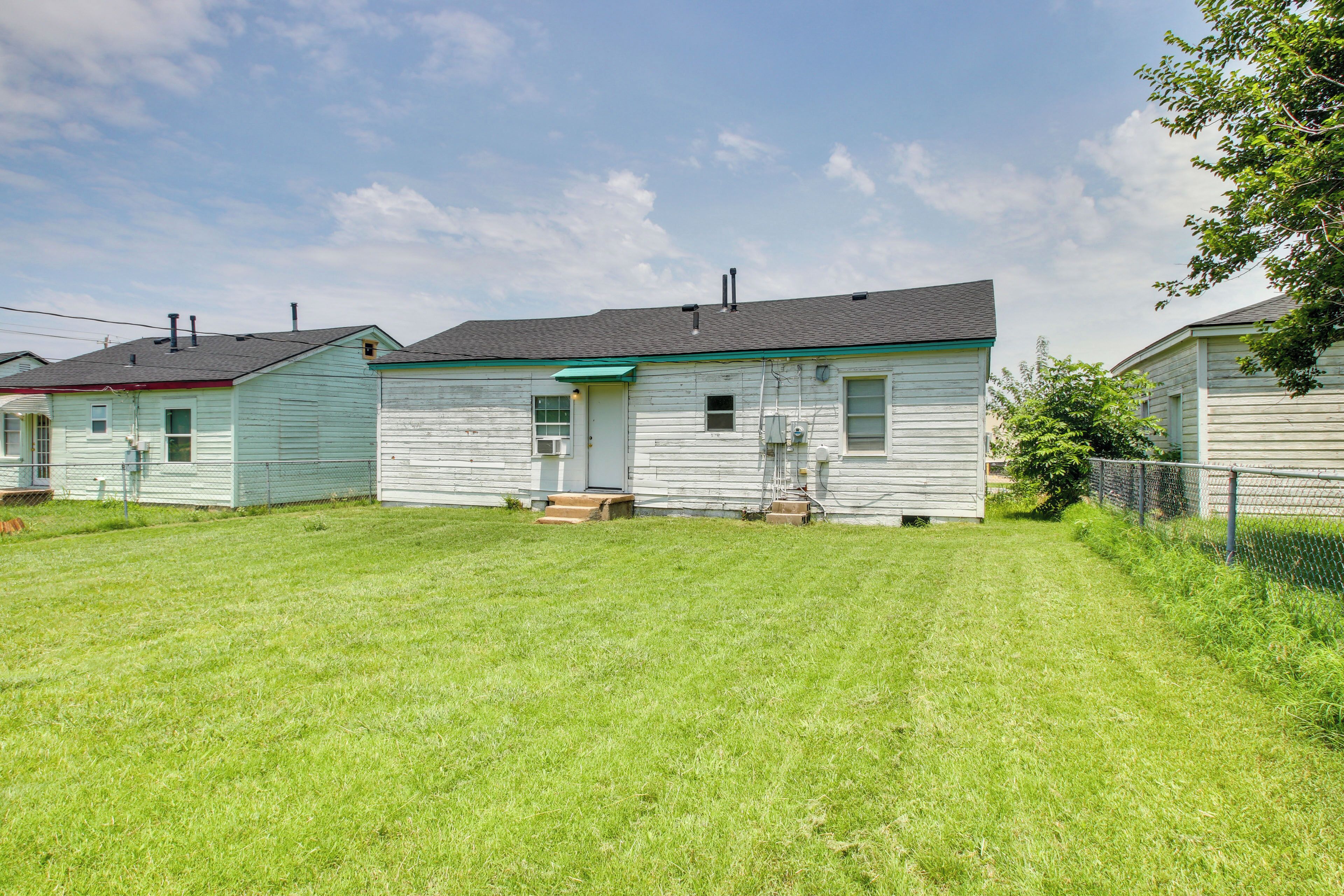 A row of single-story houses with a grassy yard in front.