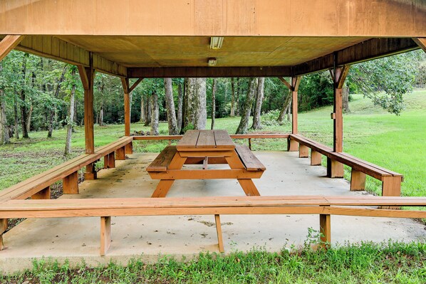 A picnic shelter with a concrete floor and wooden benches.