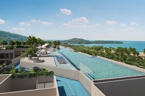 Una piscina infinita en la azotea con sillones, palmeras y vistas al mar y las colinas.