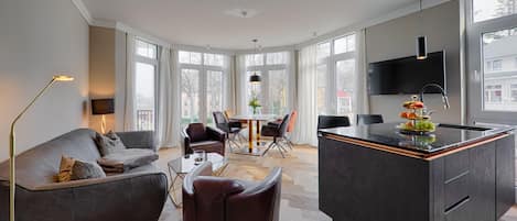 Una sala moderna con sofá, sillas, mesa de comedor y una isla de cocina.