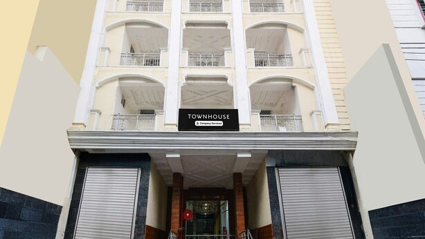 En byggnad med flera våningar, och en skylt som visar texten ”TOWNHOUSE”.