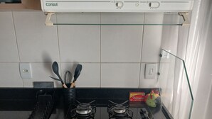 A kitchen with a gas stove, a range hood, and a box of Parana. - Premium Apartment | Pool, Kitchen and Parking Space (Rio de Janeiro)