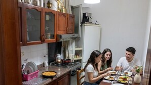 Una cocina con armarios de madera, estufa y una mesa de comedor con sillas.