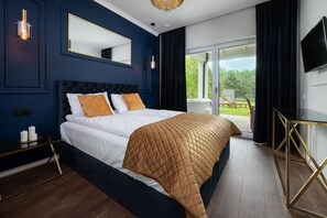 A bedroom with a large bed, a bedside table, a TV, and a view of the outdoors. - Comfortable Holiday Home, Pool, Sauna, Jacuzzi (Krokowa)