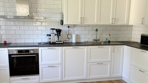 A modern kitchen with white cabinets, a built-in oven, and a coffee maker. - 4 Star Holiday Home in Gotlands Tofta (Gotlands Tofta)