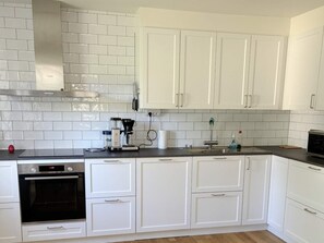 A modern kitchen with white cabinets, a built-in oven, and a coffee maker. - 4 Star Holiday Home in Gotlands Tofta (Gotlands Tofta)