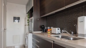 A modern kitchen with a washing machine, a coffee maker, a toaster, and a sink. - MOT Concepcion Arenal (Buenos Aires)