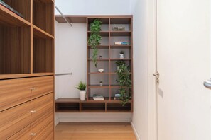 Una estantería de madera con varios estantes, algunos con libros y otros con adornos.