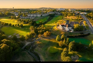 Ilmakuva golfkentästä, jossa näkyy myös klubitalo, ympäröivät rakennukset ja tie.