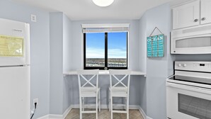 Una cocina con horno empotrado, refrigerador y ventana con vistas al paisaje.