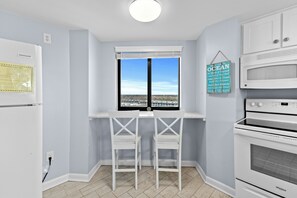 Eine Küche mit Einbauofen, Kühlschrank und einem Fenster mit Blick auf die Landschaft.