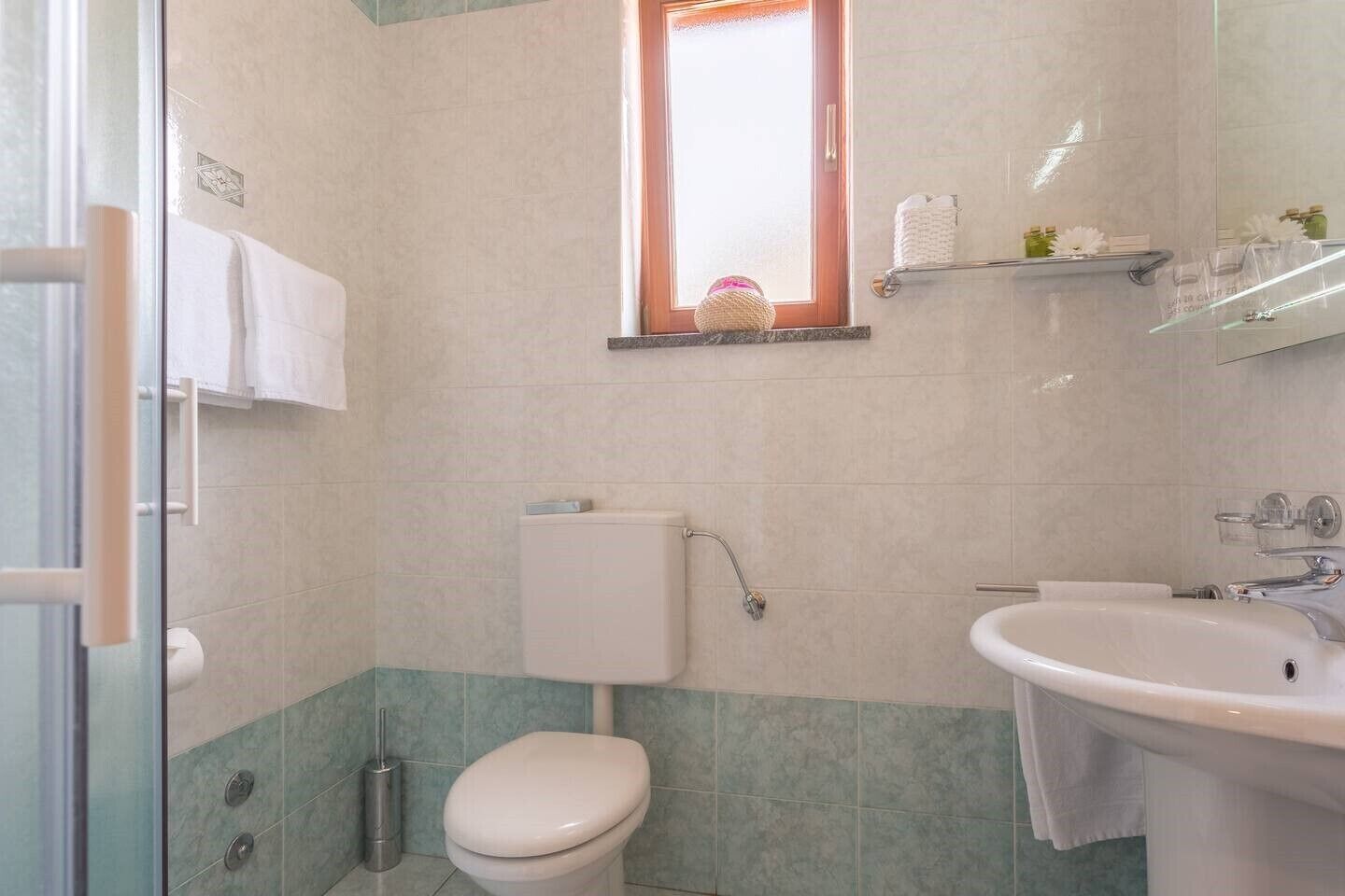 Une salle de bain avec des toilettes, un lavabo et une fenêtre.