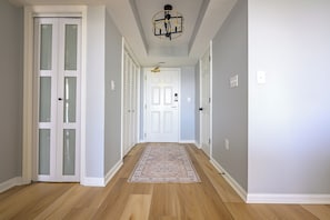 A hallway with wooden flooring, white doors, and a patterned rug. - Oceanview 3BR Brighton 1807 | Kingston Resort | Renovated (Myrtle Beach)