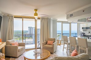 A modern living room with a balcony, large windows, and a kitchen area. - Oceanview 3BR Brighton 1807 | Kingston Resort | Renovated (Myrtle Beach)