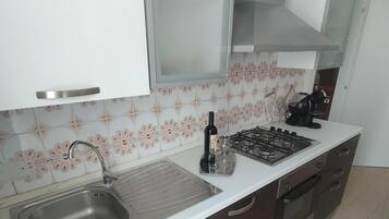 Coffee/tea maker, fridge, stovetop, cookware/dishes/utensils