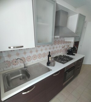 Coffee/tea maker, fridge, stovetop, cookware/dishes/utensils