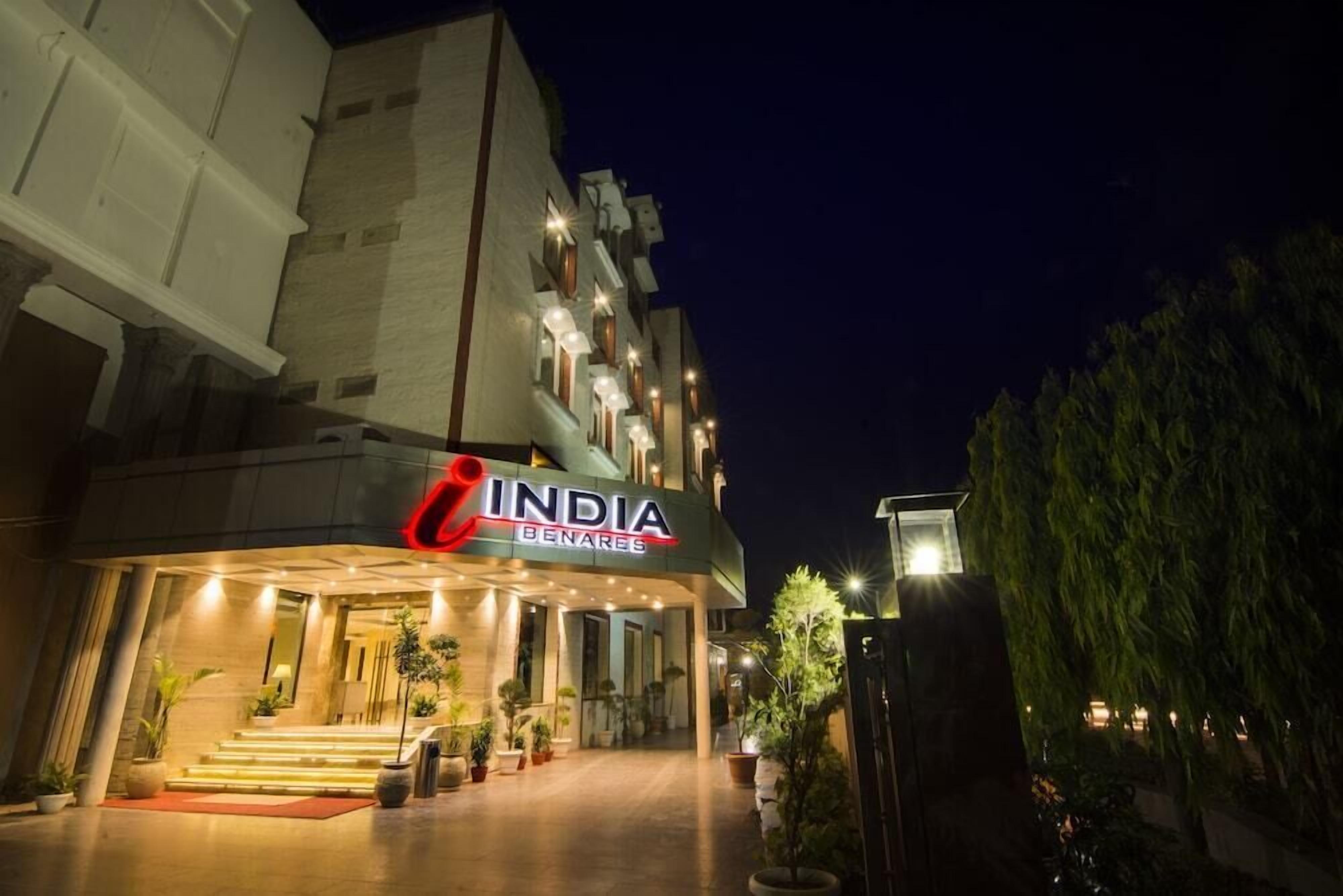 A hotel named 'India Benaras' with a modern facade, a well-lit entrance, and a staircase leading to the lobby.