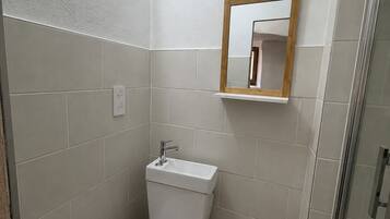 Un baño con inodoro, lavamanos y espejo.