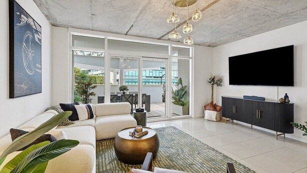 Ein modernes Wohnzimmer mit Sofa, Couchtisch und Fernseher.