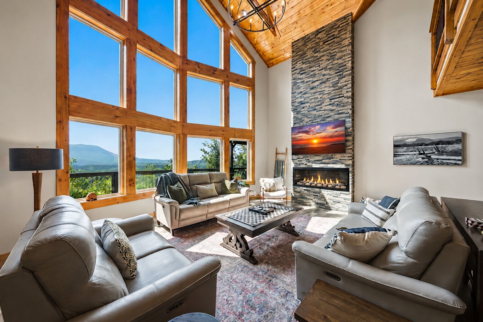 A spacious living room with large windows, a fireplace, and a view of the outdoors.